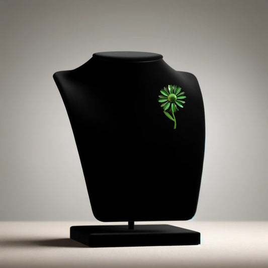 Green flower brooch with moveable stem on neutral background, vintage home decor or collectible.