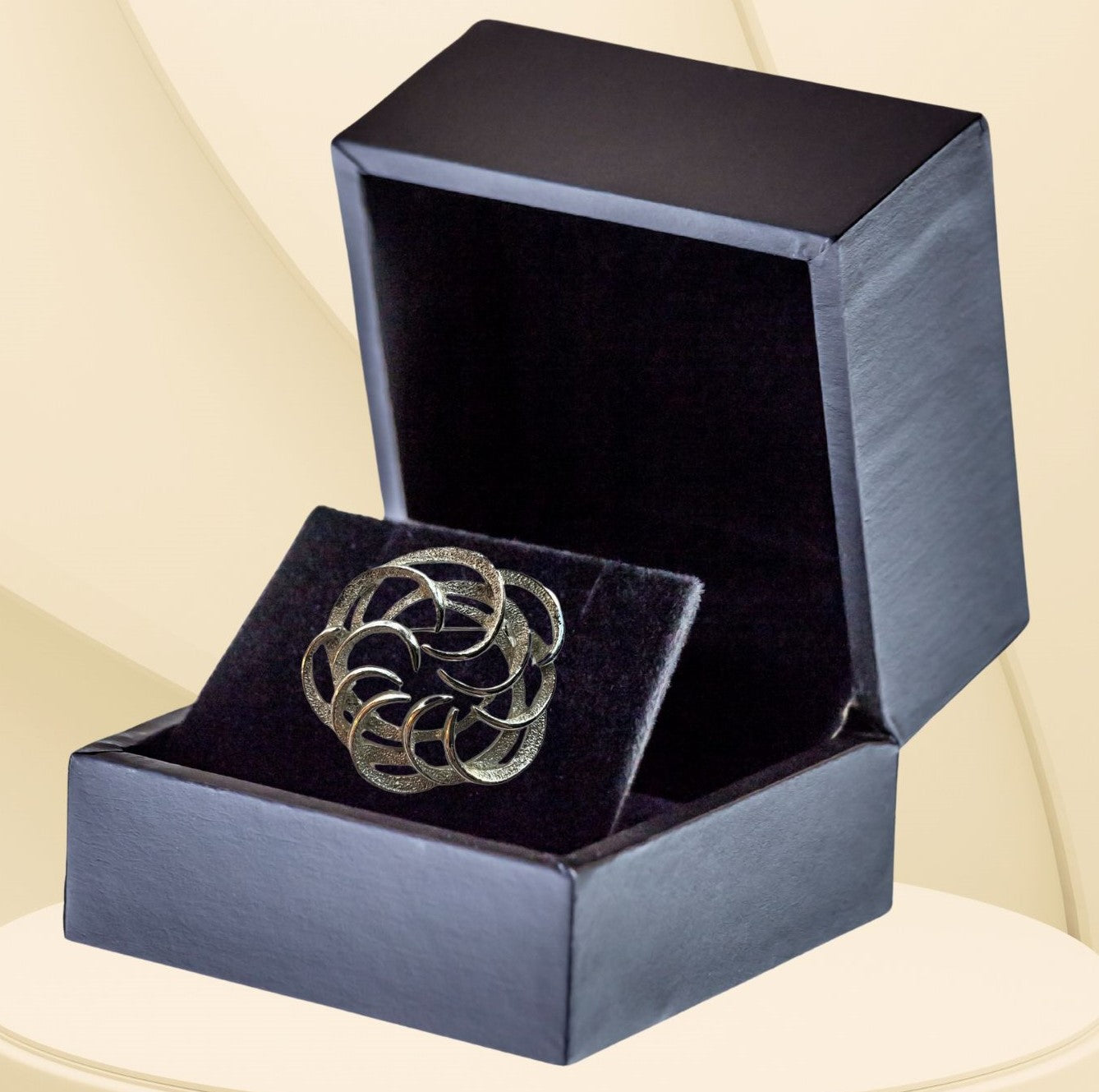 Silvertone interlocking circles brooch on neutral background, vintage home decor or collectible.