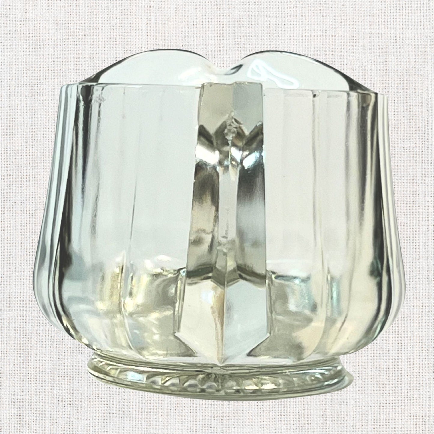 Clear glass ribbed creamer on neutral background, vintage home decor or collectible.