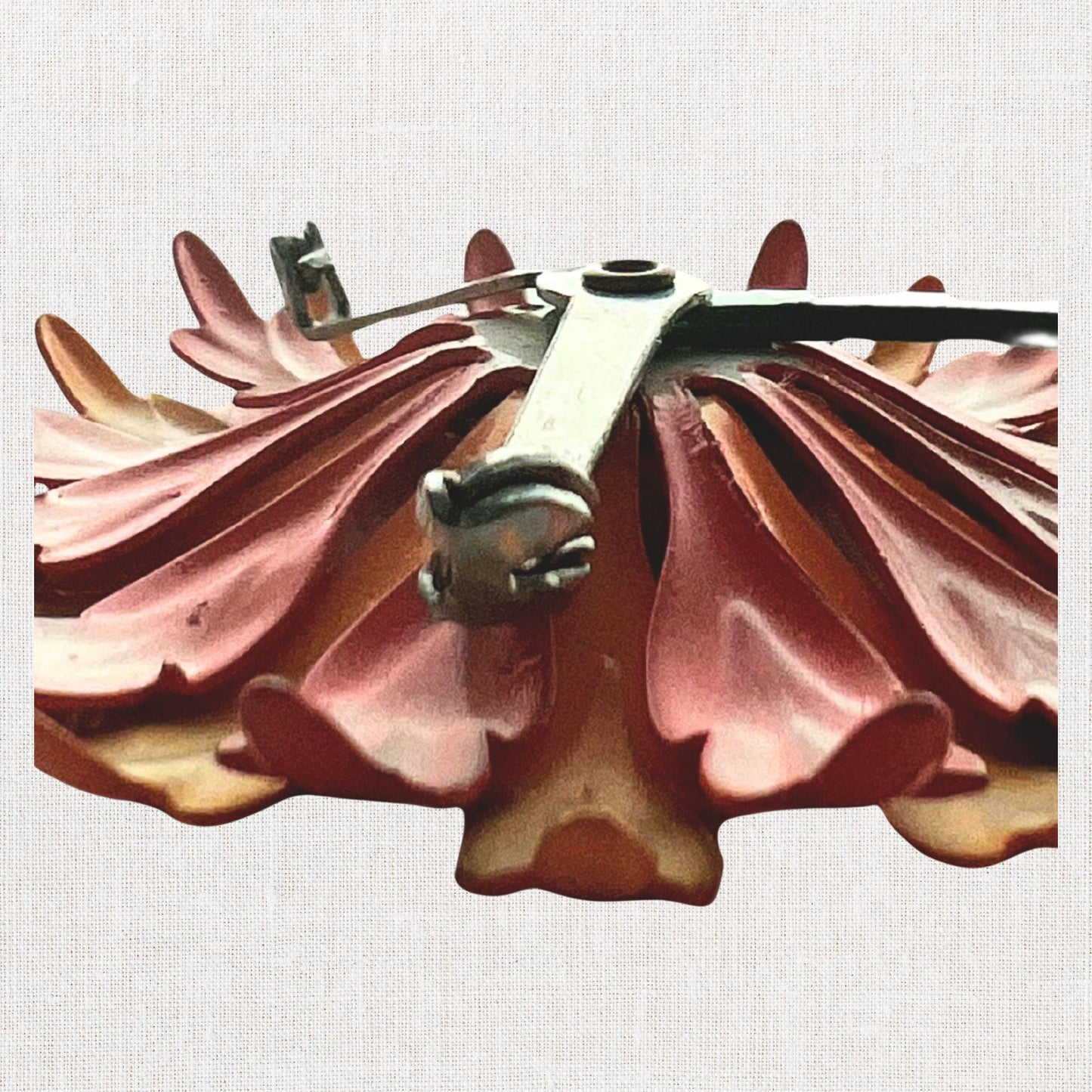 Pink flower brooch with moveable stem on neutral background, vintage home decor or collectible.