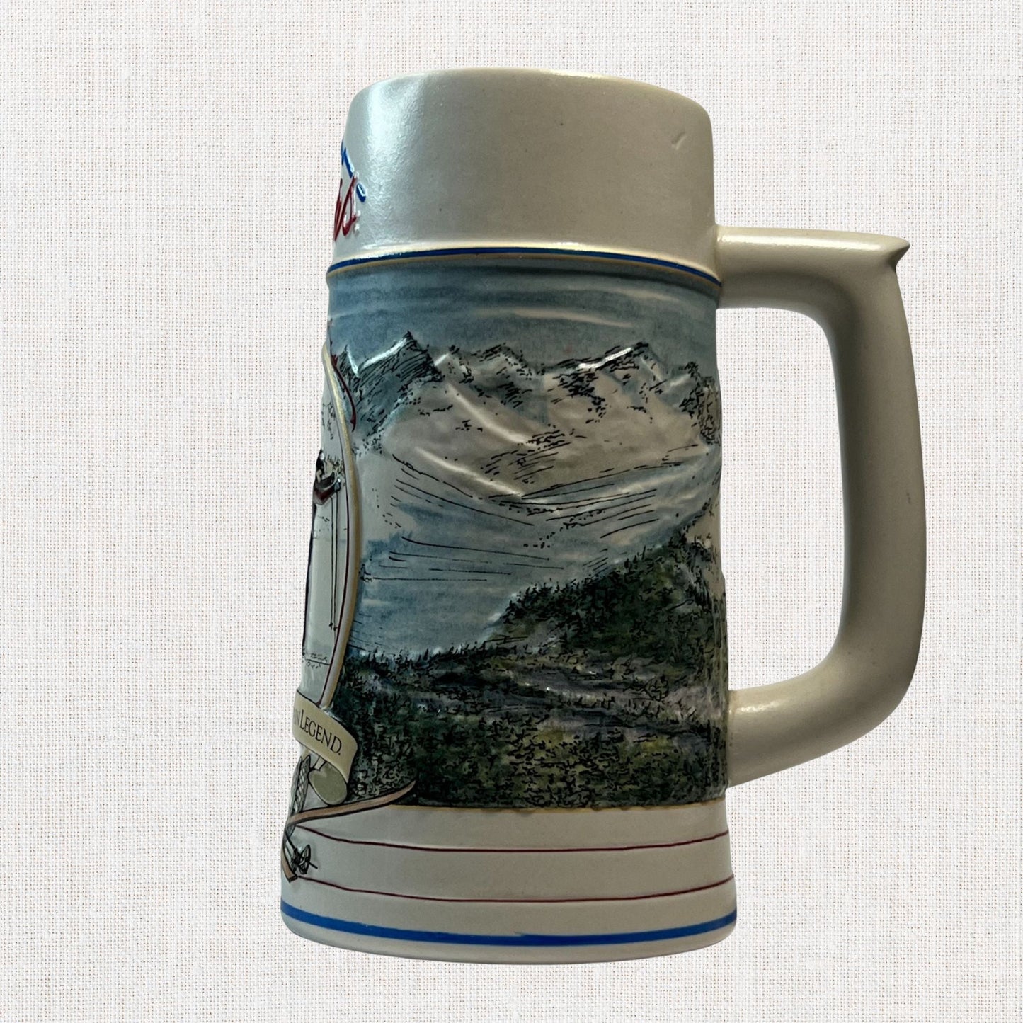 Coors 1990 ceramic beer stein with mountain motif, on neutral background, vintage home decor or collectible.