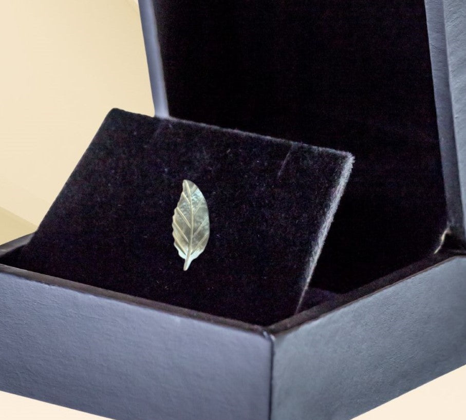 Mother of pearl miniature leaf brooch on neutral background, vintage home decor or collectible.