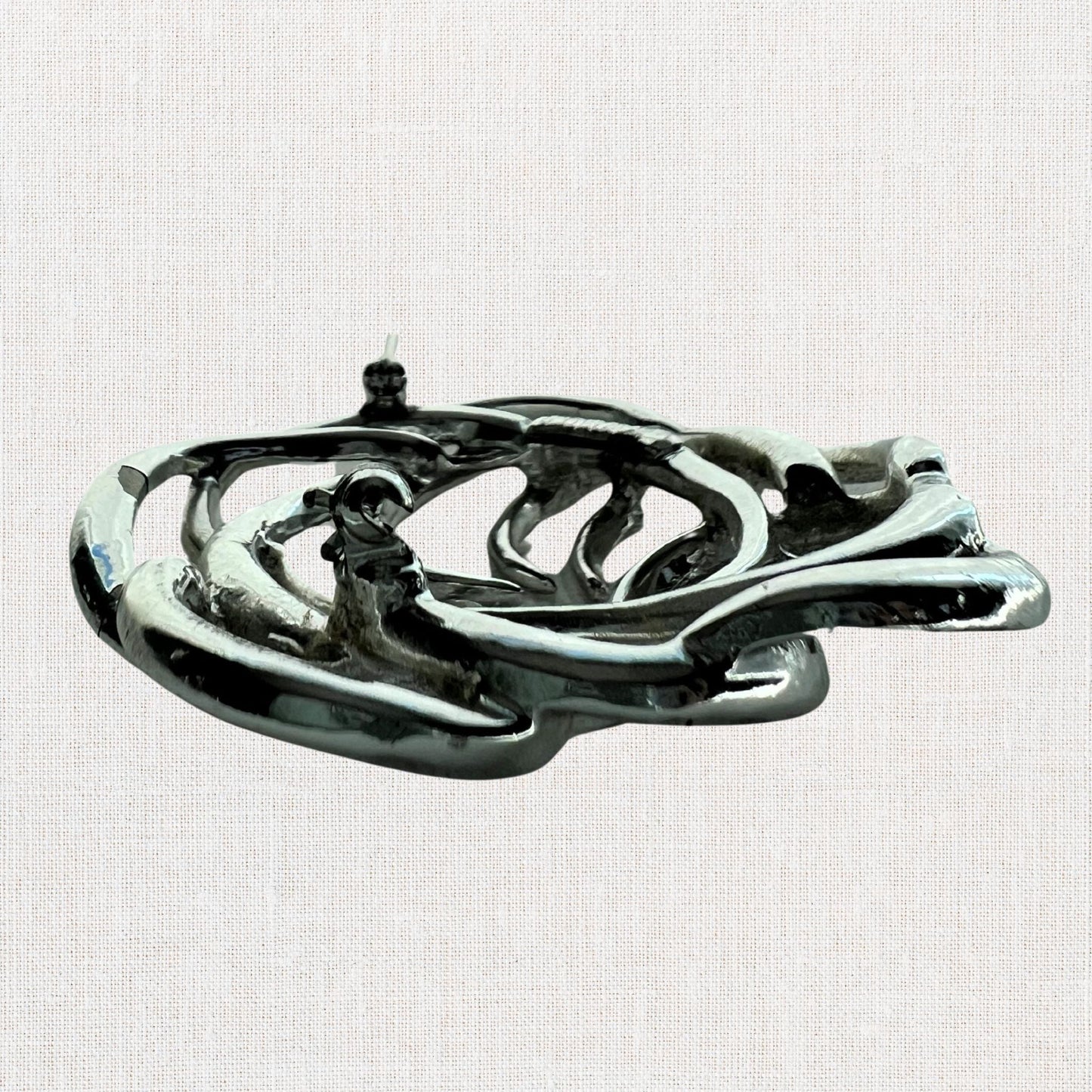 Silvertone interlocking circles brooch on neutral background, vintage home decor or collectible.