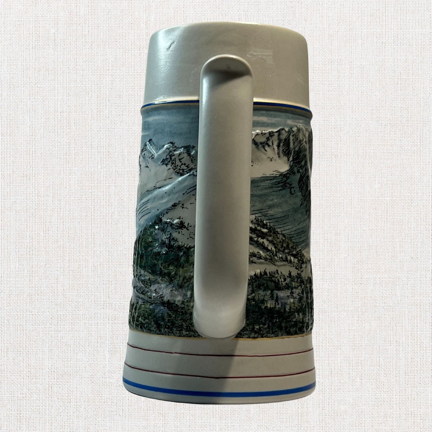 Coors 1990 ceramic beer stein with mountain motif, on neutral background, vintage home decor or collectible.