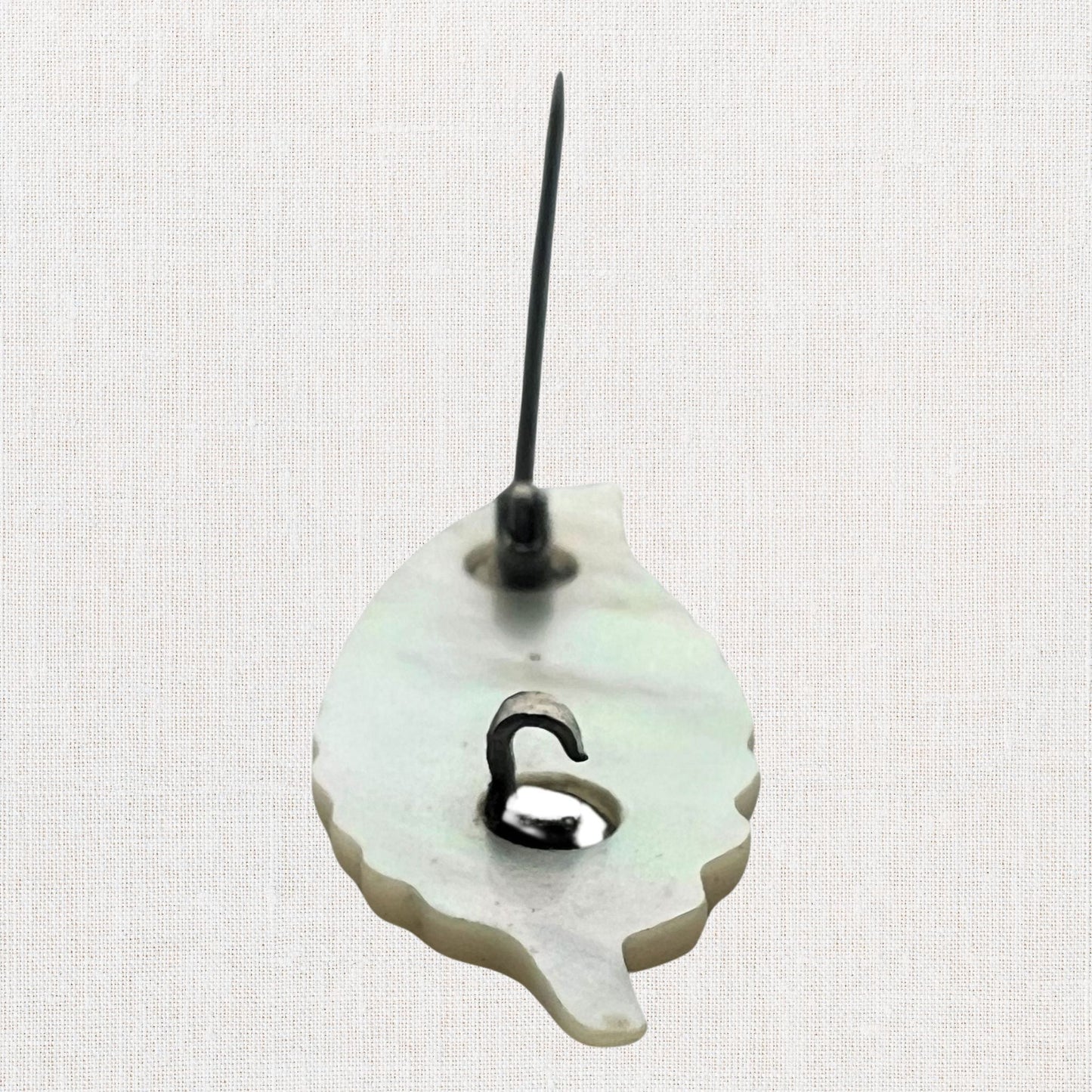 Mother of pearl miniature leaf brooch on neutral background, vintage home decor or collectible.