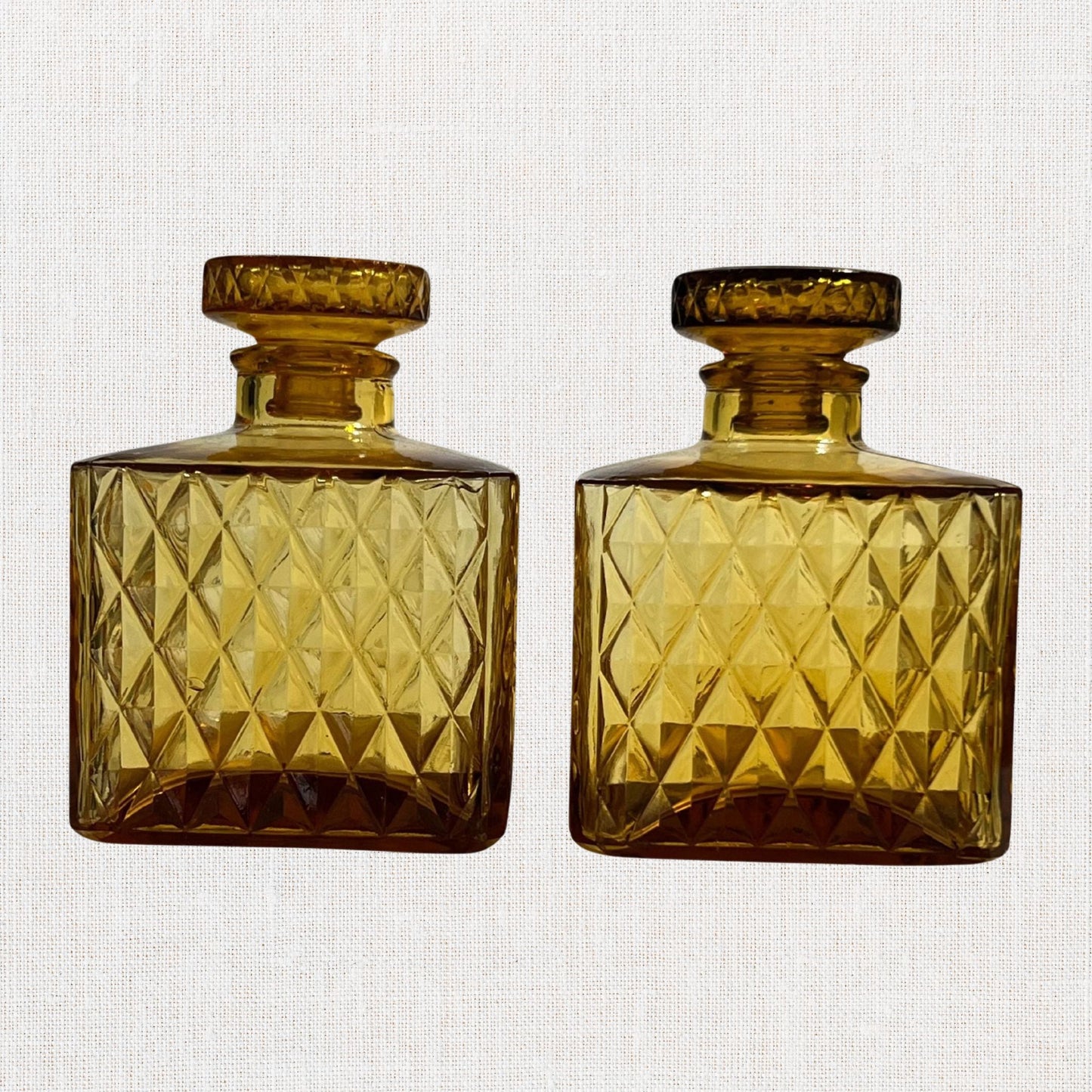 Amber diamond cut square decanter set on neutral background, vintage home decor or collectible.