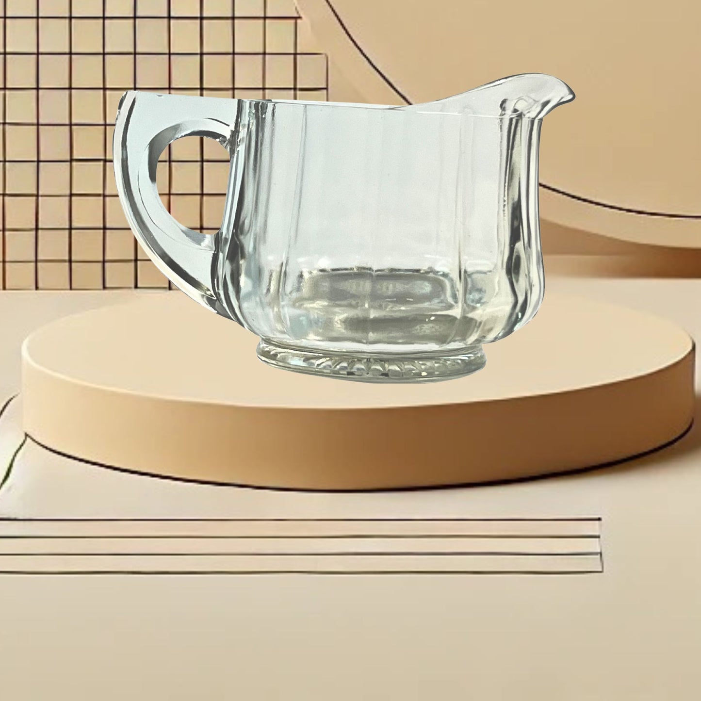 Clear glass ribbed creamer on neutral background, vintage home decor or collectible.