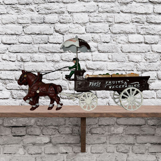 Cast iron horse drawn produce wagon on neutral background, vintage home decor or collectible.