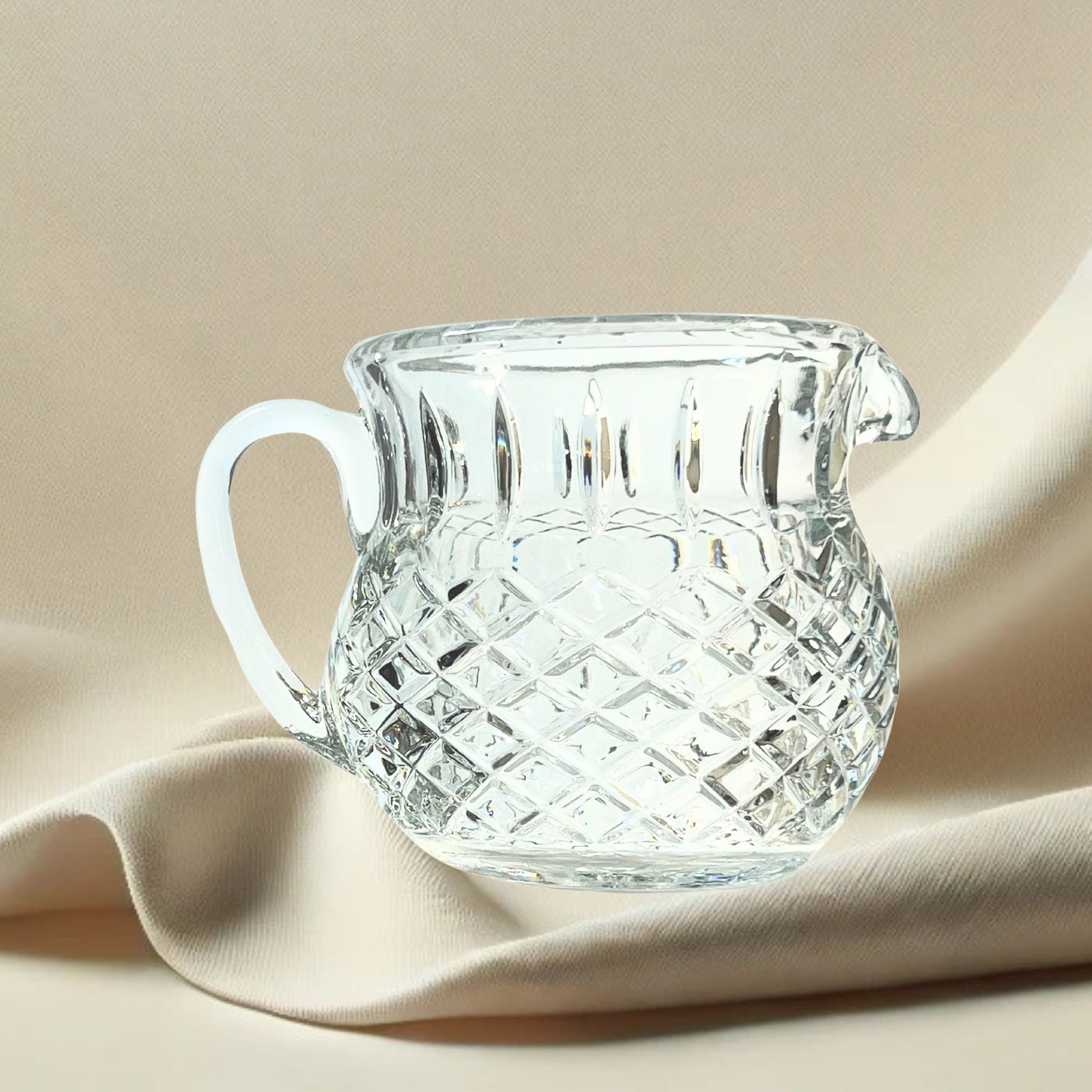 Diamond cut crystal stout pitcher on neutral background, vintage home decor or collectible.