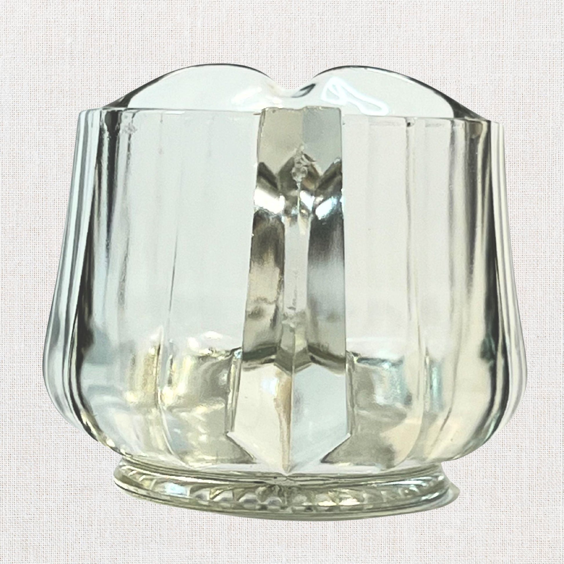 Clear glass ribbed creamer on neutral background, vintage home decor or collectible.