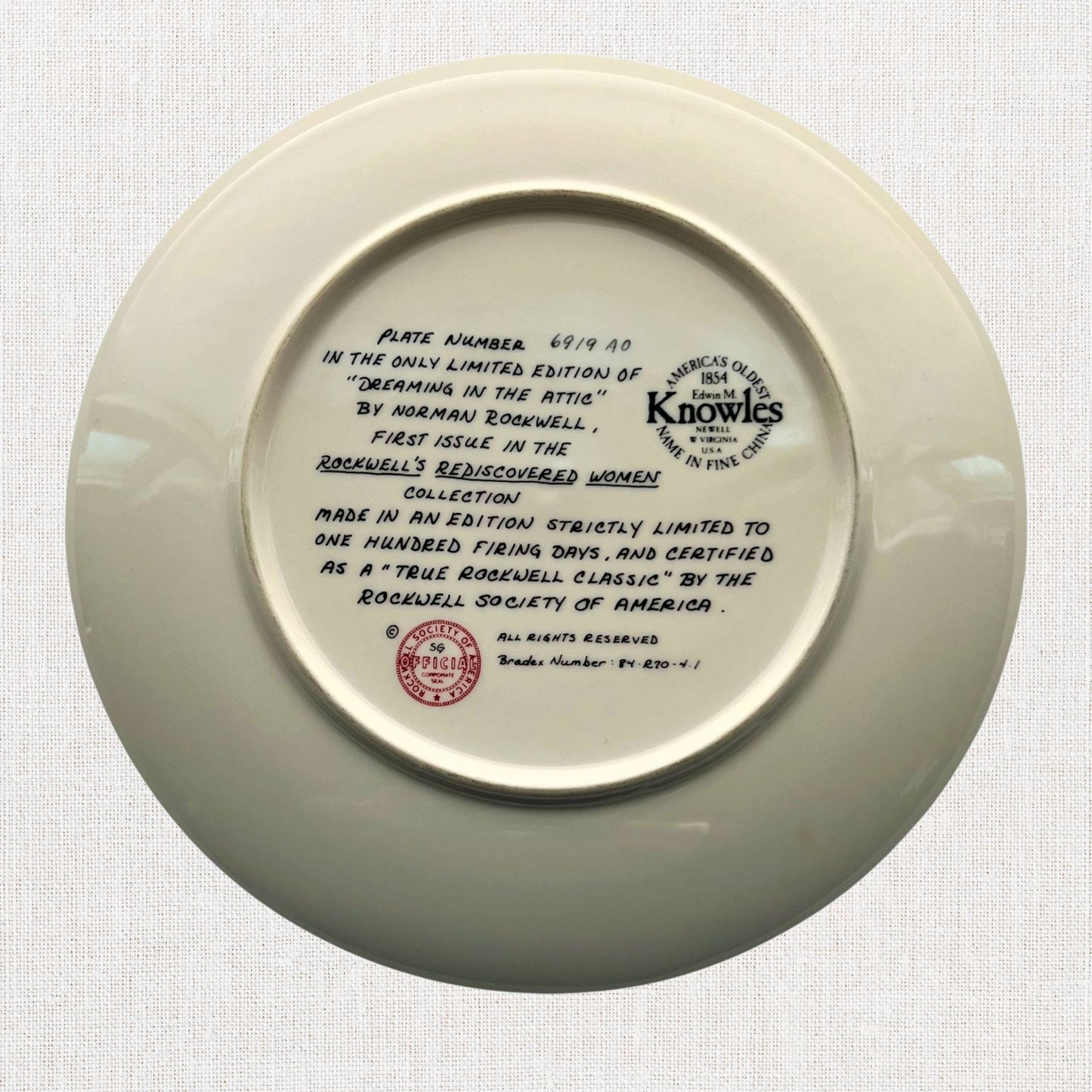 Norman rockwell dreaming in the attic plate on neutral background, vintage home decor or collectible.