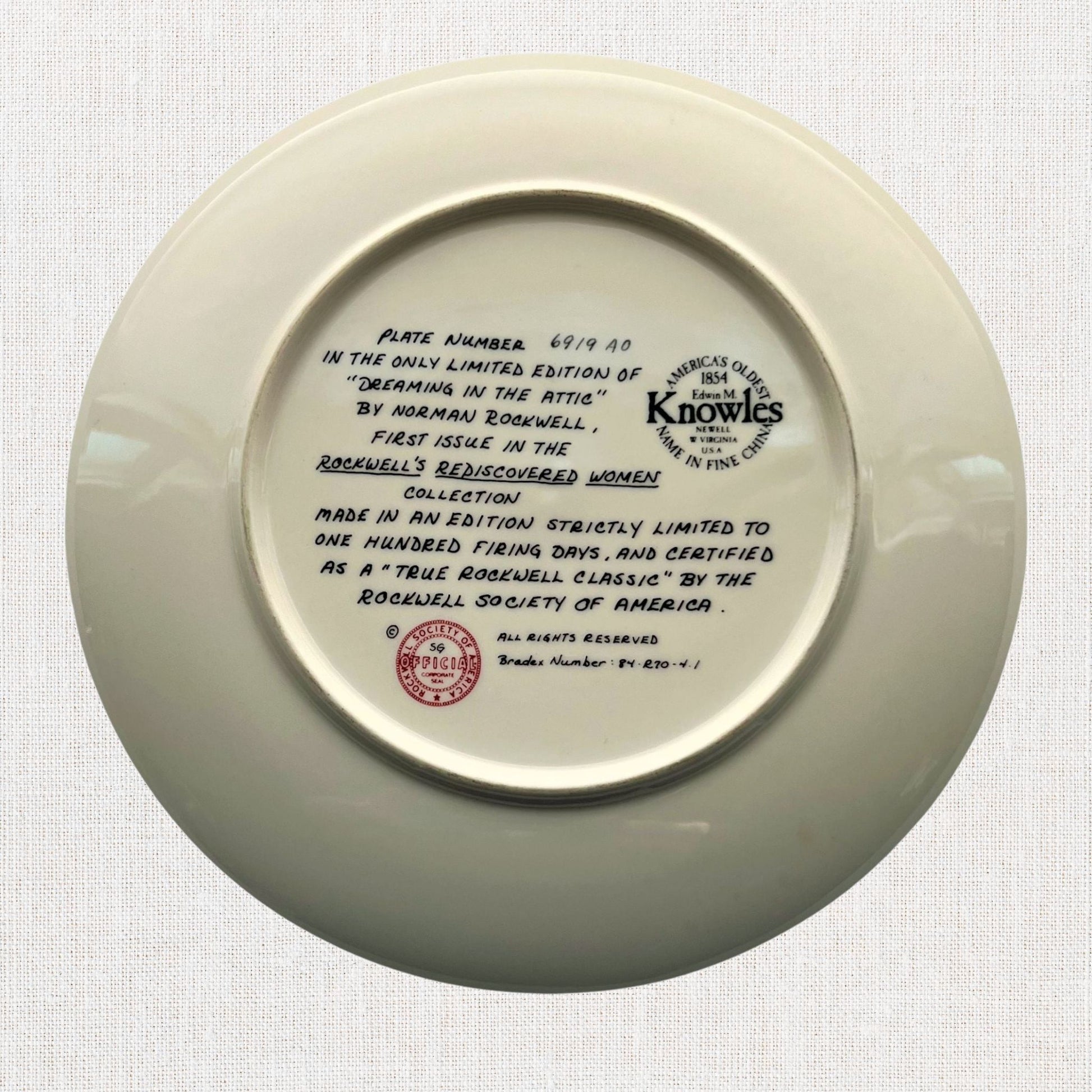 Norman rockwell dreaming in the attic plate on neutral background, vintage home decor or collectible.