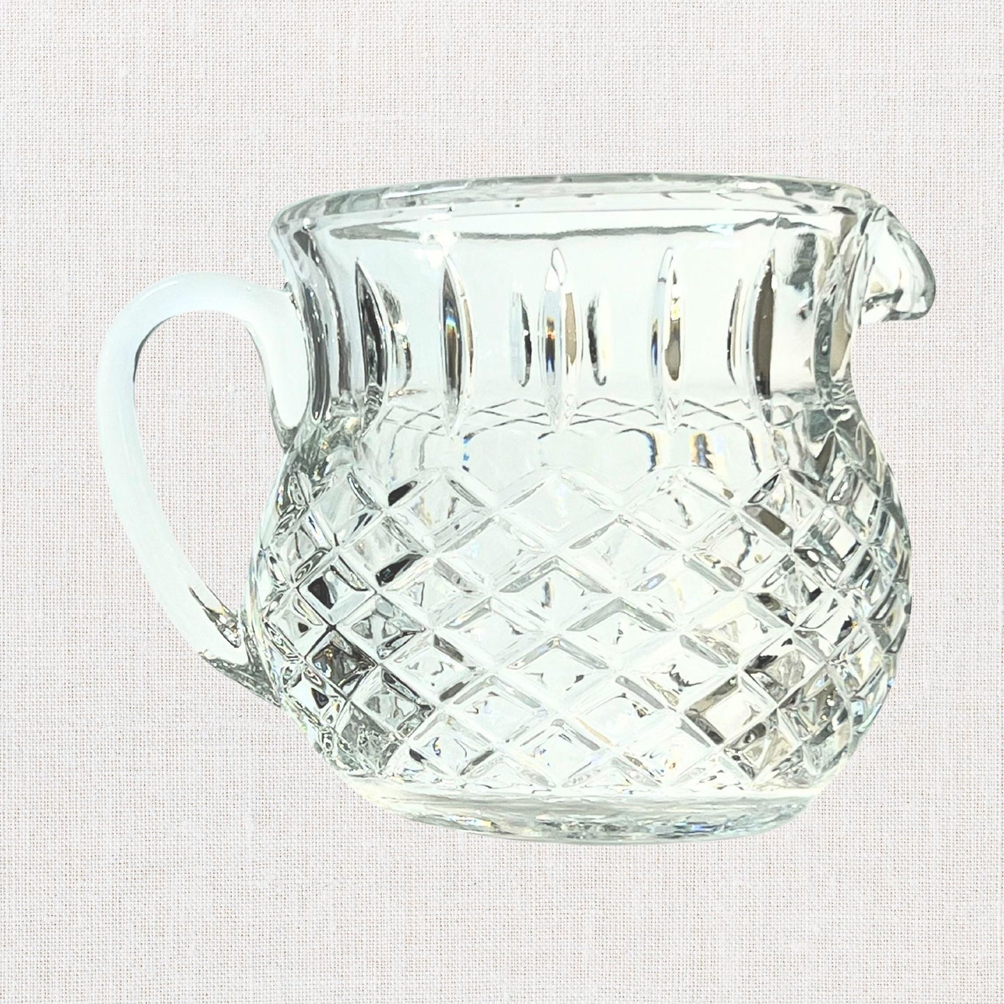 Diamond cut crystal stout pitcher on neutral background, vintage home decor or collectible.