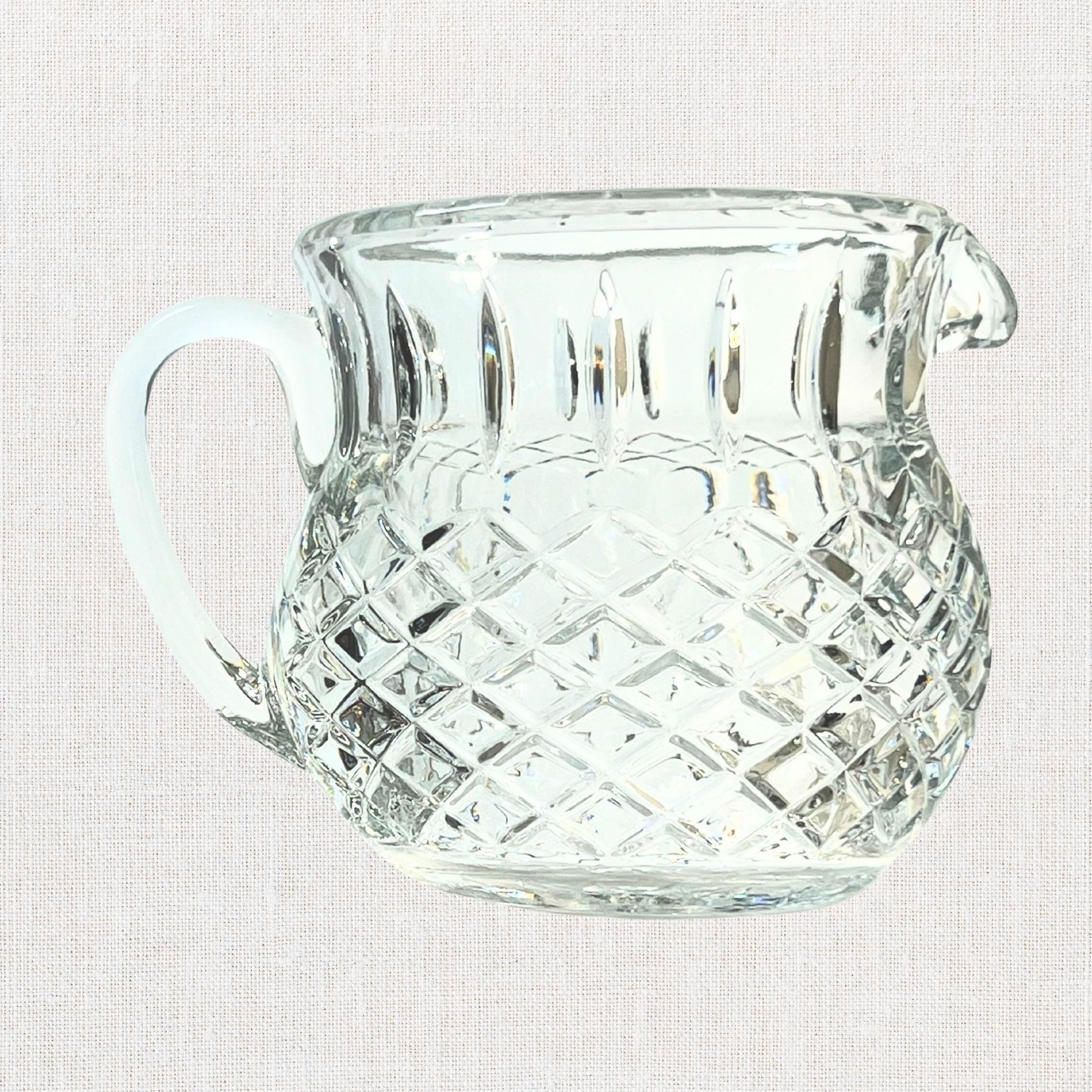 Diamond cut crystal stout pitcher on neutral background, vintage home decor or collectible.