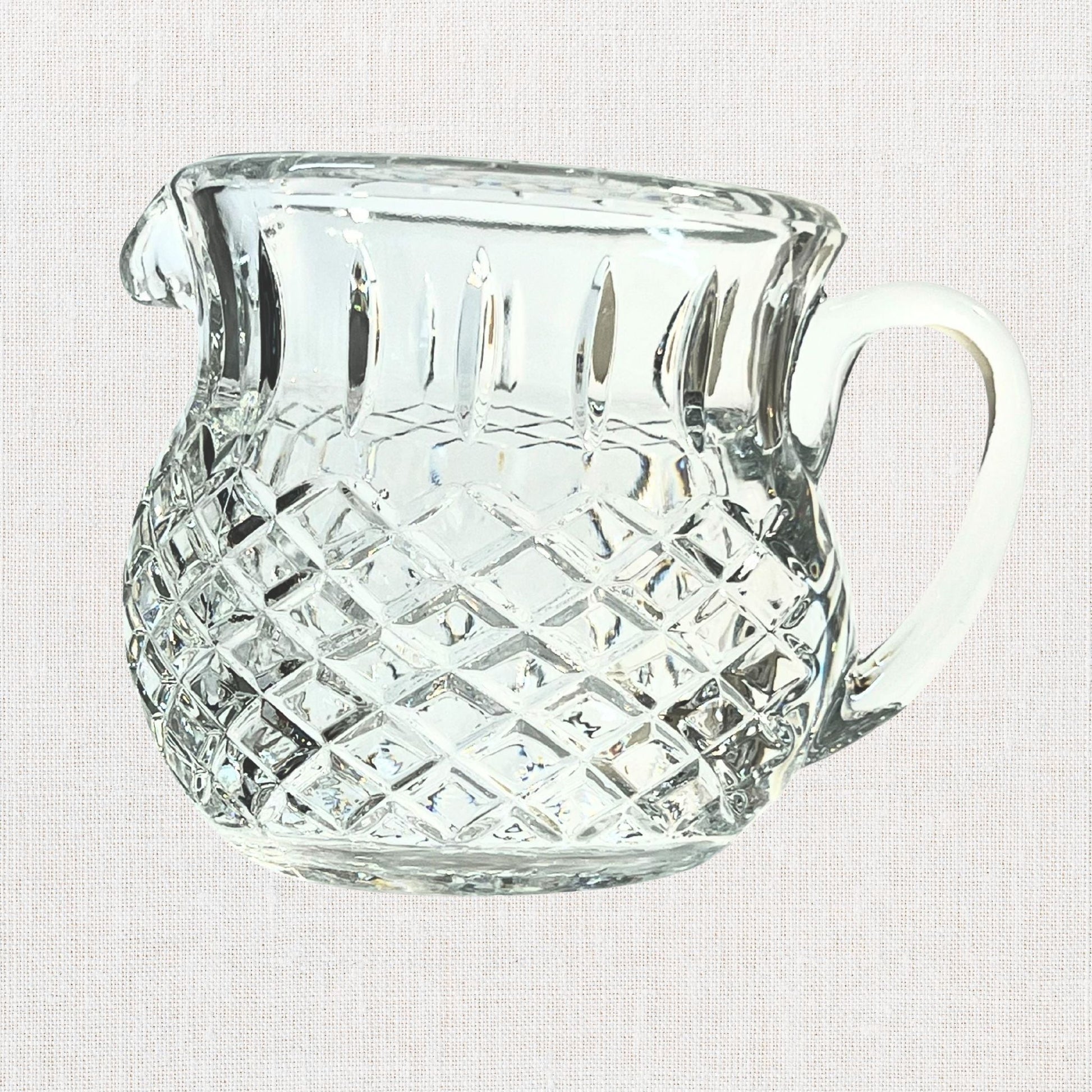 Diamond cut crystal stout pitcher on neutral background, vintage home decor or collectible.