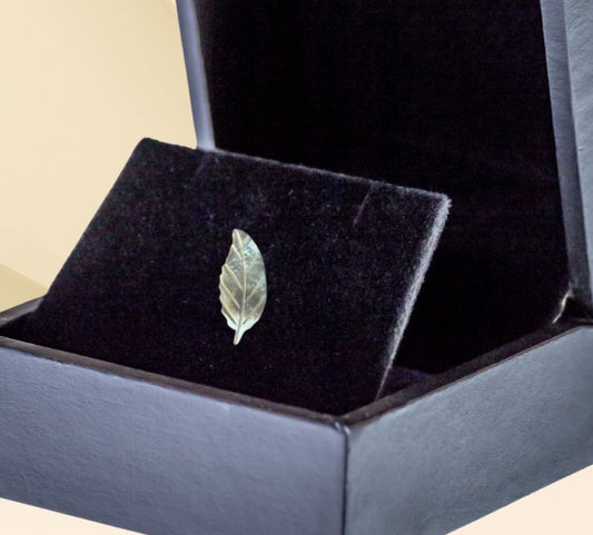 Mother of pearl miniature leaf brooch on neutral background, vintage home decor or collectible.